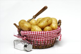 Jacket potatoes in basket and salt shaker