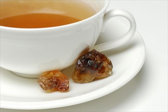 Cup of tea and brown rock candy