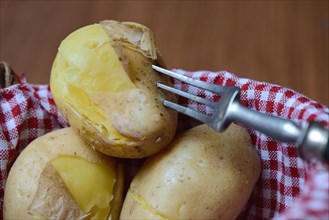 Boiled potatoes with fork in basket