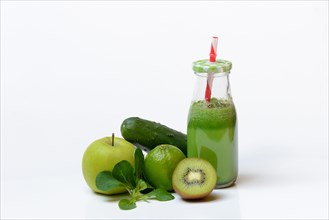 Green smoothie in glass with straw and fruit and vegetables
