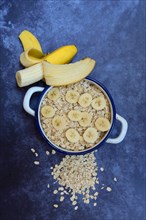 Oat flakes in bowl with banana slices