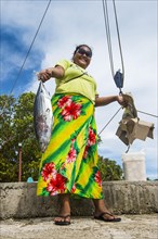 Local woman presenting fresh tuna fish