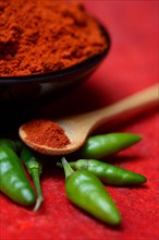 ( Capsicum annuum) Chilli powder in bowl and spoon and green chillies, paprika powder, chillies,