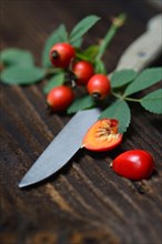 Rose hips with kitchen knife