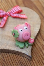 Marzipan lucky pig on a wooden heart