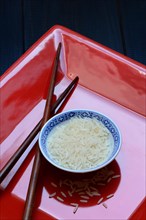 Rice grains in bowls and chopsticks