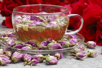 Rose tea in cup and rose buds
