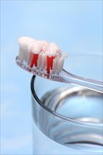 Sodium powder on toothbrush and glass with water