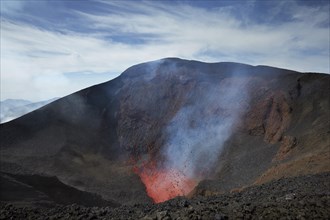 Tolbachik volcano crater spews glowing lava and smoke