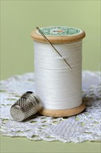 Thread roll with sewing needle and thimble