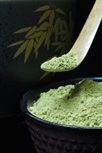 Japanese Matcha tea in bowl with bamboo spoon