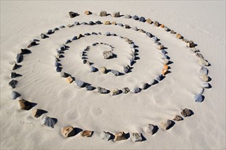 Spiral of stones on sandy beach