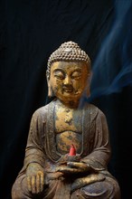 Buddha with burning incense cone