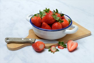 Strawberries in skin on wooden board