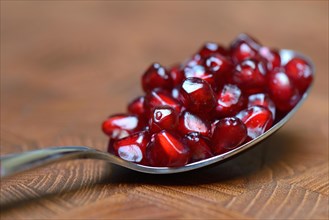 Pomegranate seeds on spoon