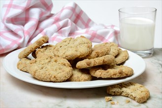 Oatmeal biscuits on plate and glass of milk