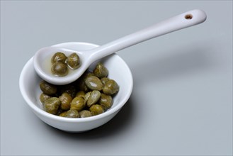 Bowl and porcelain spoon with capers