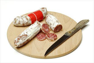 Salametti with knife on wooden board