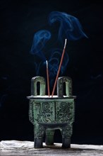 Incense burner with burning incense sticks