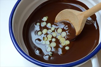 Liquid chocolate coating and melting cocoa butter with spoon