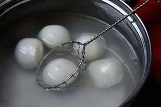 Glutinous rice balls in pot with hot water