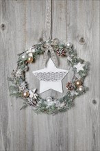 Christmas wreath on wooden wall with star