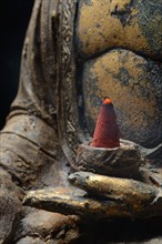 Buddha with burning incense cone