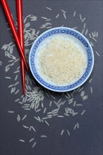 Rice grains in husk and chopsticks