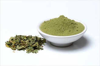 Moringa powder in bowl and moringa leaves