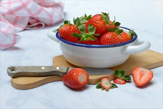 Strawberries in skin on wooden board