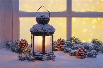 Lantern with Christmas decoration on windowsill