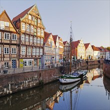 Historic merchant and warehouse houses at the Hanseatic port with the sailing ship Willi
