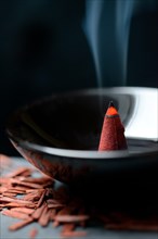 Burning incense cone and sandalwood