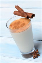 Cinnamon milk in glass with cinnamon sticks and star anise
