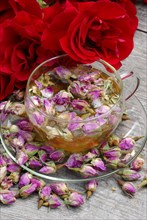 Rose tea in cup and rose buds