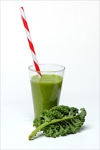 Kale smoothie in glass with drinking straw