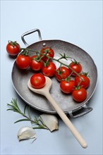 Cherry tomatoes in shell with garlic and rosemary branch