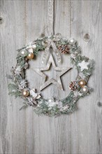 Christmas wreath on wooden wall with star