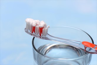 Sodium powder on toothbrush and glass with water