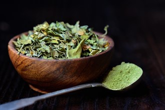 Moringa leaves in bowl and moringa powder in spoon