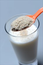 Tigernut flour in spoon and glass of milk
