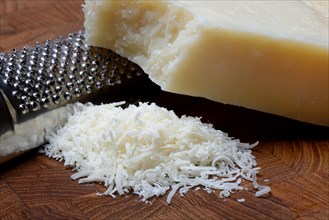 Grated Parmesan cheese and piece of Parmesan cheese