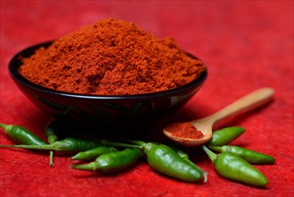( Capsicum annuum) Chilli powder in bowl and spoon and green chillies, paprika powder, chillies,