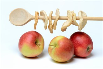 Apples and apple rings on wooden spoon