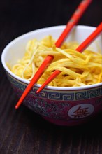Chinese noodles in bowl with chopsticks
