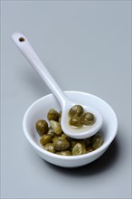 Bowl and porcelain spoon with capers