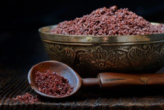 Sumac powder in bowl and spoon
