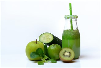 Green smoothie in glass with straw and fruit and vegetables