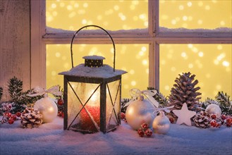 Lantern with Christmas decoration on windowsill