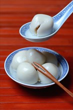 Glutinous rice balls with peanut filling in bowl and spoon